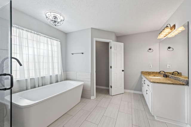 bathroom featuring separate shower and tub, a textured ceiling, and vanity