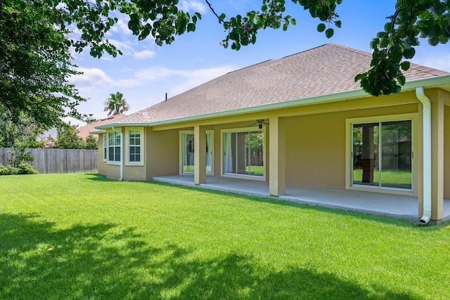 back of house featuring a lawn and a patio