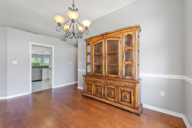 unfurnished dining area featuring a notable chandelier and hardwood / wood-style floors