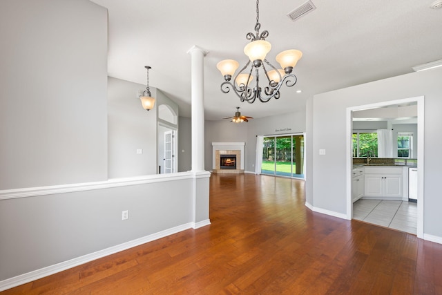 unfurnished living room with ceiling fan with notable chandelier, hardwood / wood-style flooring, and sink