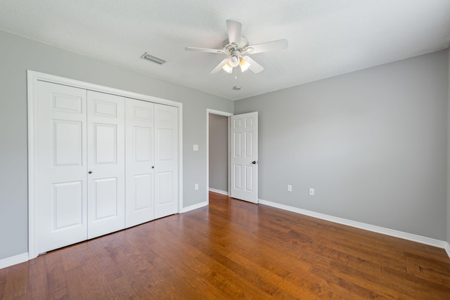 unfurnished bedroom with ceiling fan, dark hardwood / wood-style floors, and a textured ceiling