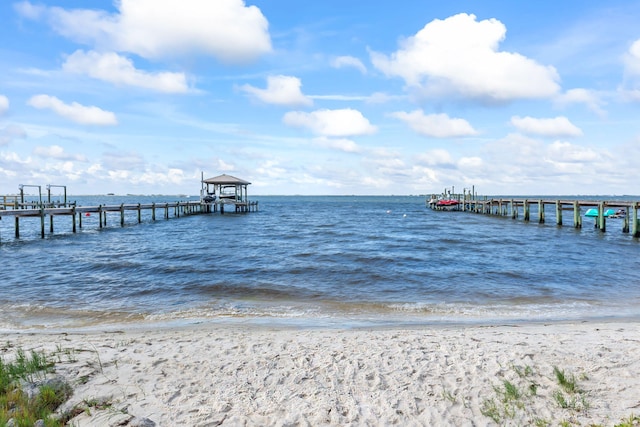 dock area featuring a beach view and a water view