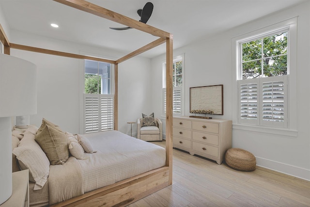 bedroom with multiple windows and light hardwood / wood-style flooring