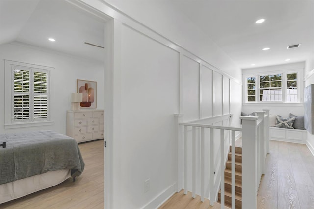 hallway featuring vaulted ceiling and light wood-type flooring