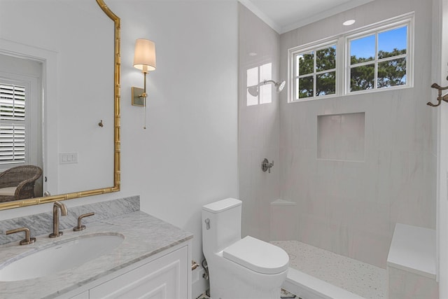 bathroom with toilet, a tile shower, crown molding, and vanity