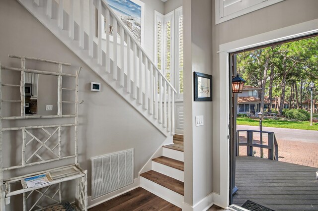 stairway with dark hardwood / wood-style floors