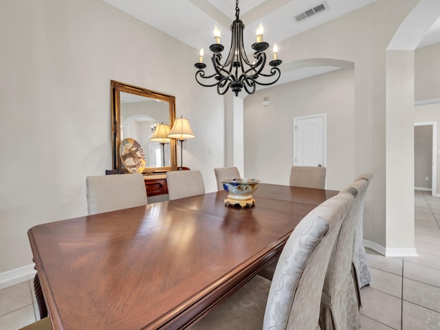 dining space with light tile patterned floors and an inviting chandelier