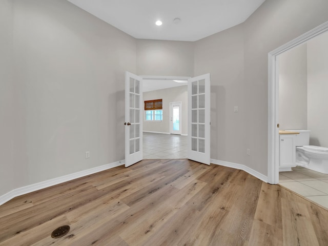 unfurnished room featuring french doors and light hardwood / wood-style flooring