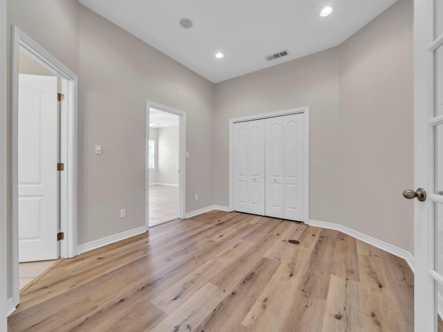 unfurnished bedroom featuring light hardwood / wood-style flooring and a closet