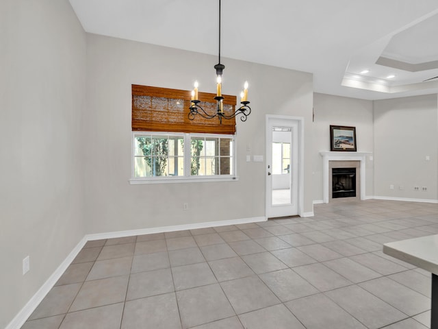 unfurnished living room featuring a tray ceiling, crown molding, light tile patterned floors, and a notable chandelier