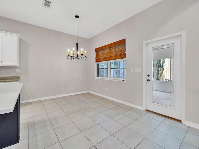 unfurnished dining area with light tile patterned floors and an inviting chandelier