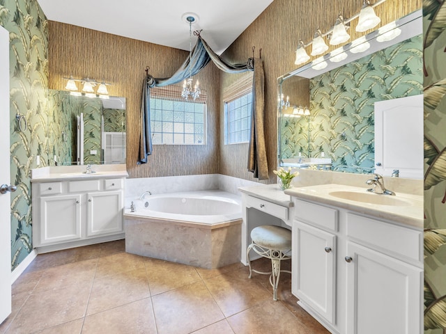 bathroom with tile patterned floors, vanity, a relaxing tiled tub, and an inviting chandelier