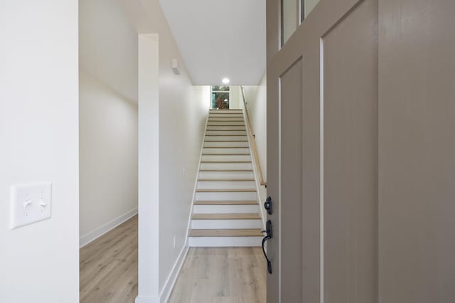 stairs with wood finished floors and baseboards