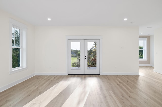 spare room featuring recessed lighting, french doors, baseboards, and light wood finished floors