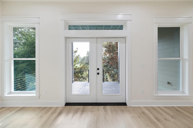 doorway to outside with french doors, baseboards, and wood finished floors