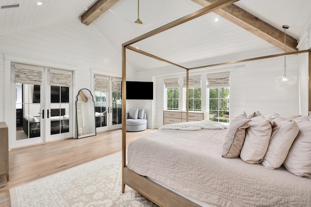 bedroom with wooden walls, wood finished floors, visible vents, lofted ceiling with beams, and french doors