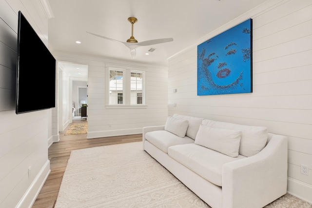 living room featuring a ceiling fan, wood finished floors, baseboards, recessed lighting, and crown molding