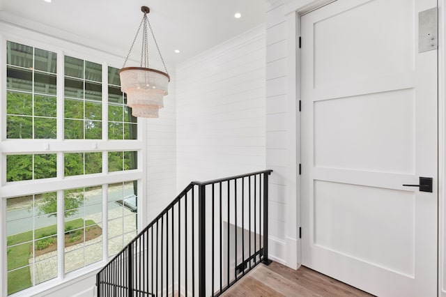 interior space featuring recessed lighting, a notable chandelier, wood finished floors, and ornamental molding