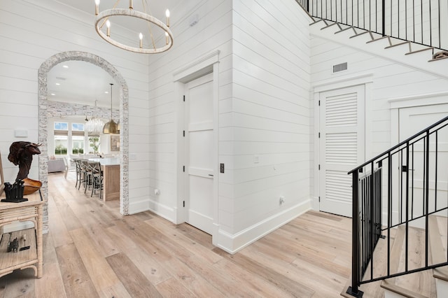 hallway featuring a notable chandelier, stairs, and hardwood / wood-style flooring