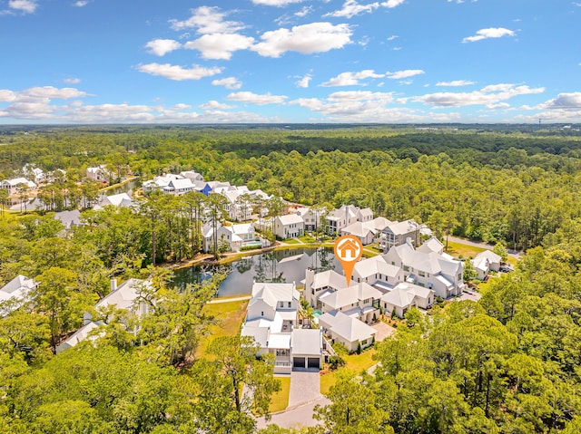 aerial view featuring a forest view, a residential view, and a water view