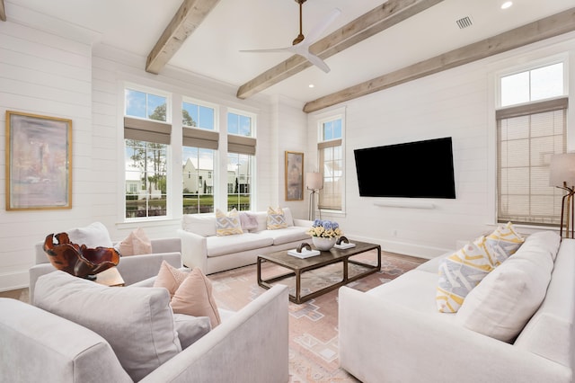 living room with ceiling fan, plenty of natural light, and beamed ceiling