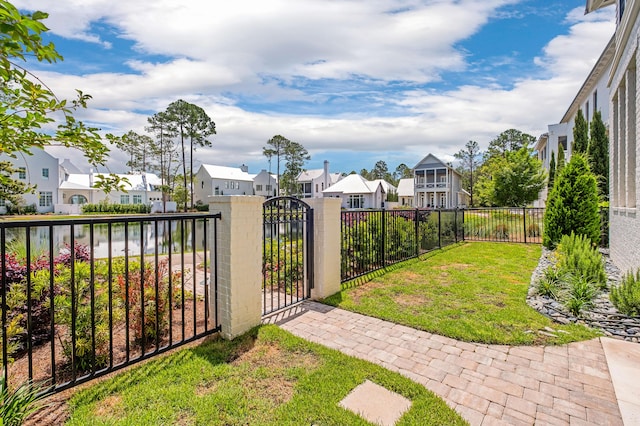 view of yard featuring a residential view, fence private yard, and a gate