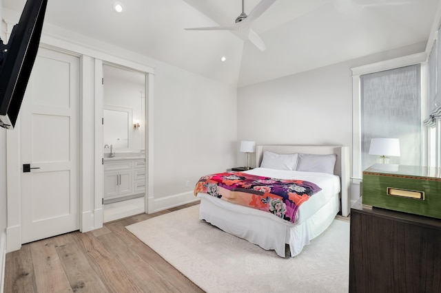 bedroom featuring ensuite bath, recessed lighting, light wood-style floors, baseboards, and vaulted ceiling