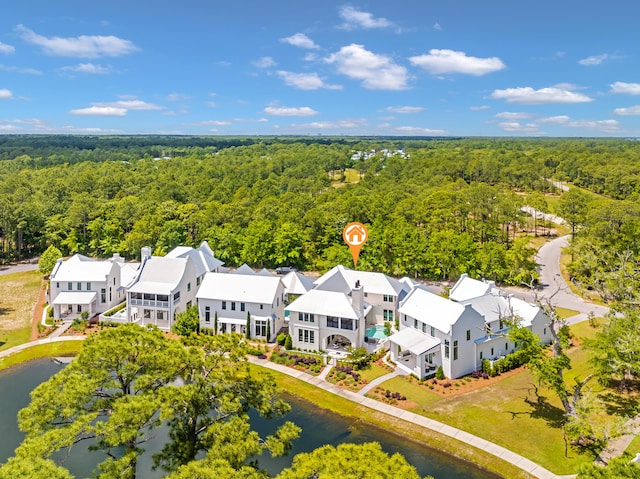 drone / aerial view with a forest view, a residential view, and a water view