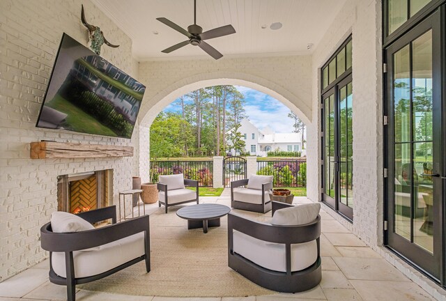 view of patio / terrace with ceiling fan and an outdoor living space with a fireplace