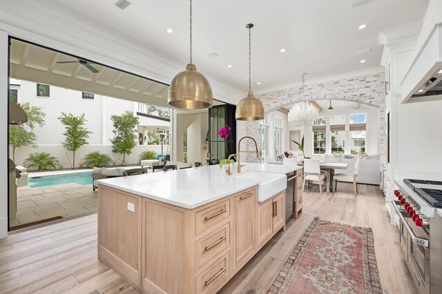 kitchen featuring appliances with stainless steel finishes, sink, plenty of natural light, and an island with sink