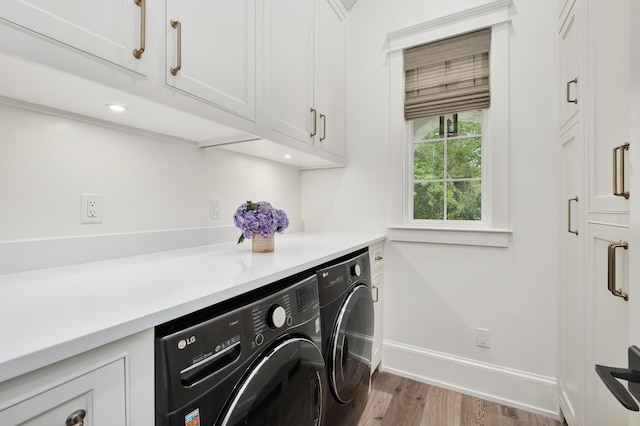 washroom with wood finished floors, cabinet space, baseboards, and washer and clothes dryer