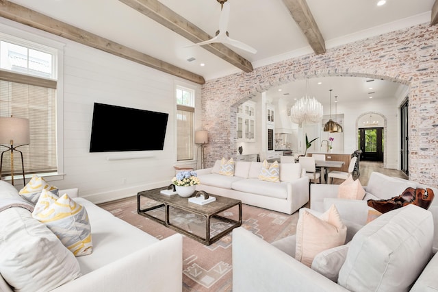 living room featuring beamed ceiling, recessed lighting, wood finished floors, arched walkways, and a notable chandelier