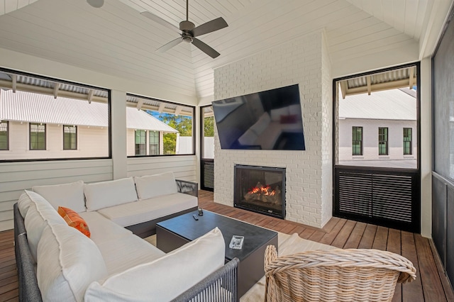 interior space featuring wood finished floors, a fireplace, lofted ceiling, wood ceiling, and ceiling fan