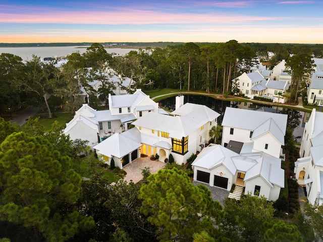 aerial view at dusk with a residential view and a water view