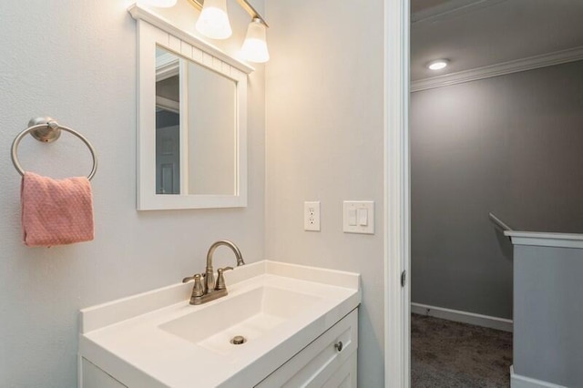 bathroom featuring ornamental molding, vanity, and baseboards