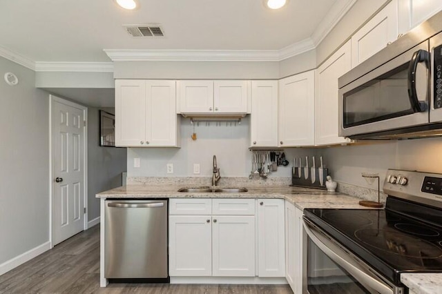 kitchen featuring stainless steel appliances, a sink, white cabinetry, and crown molding