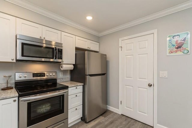 kitchen with appliances with stainless steel finishes, light stone counters, and white cabinets