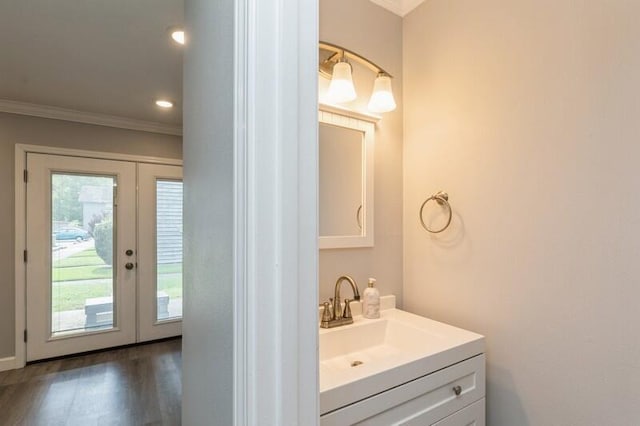 bathroom featuring recessed lighting, wood finished floors, vanity, ornamental molding, and french doors