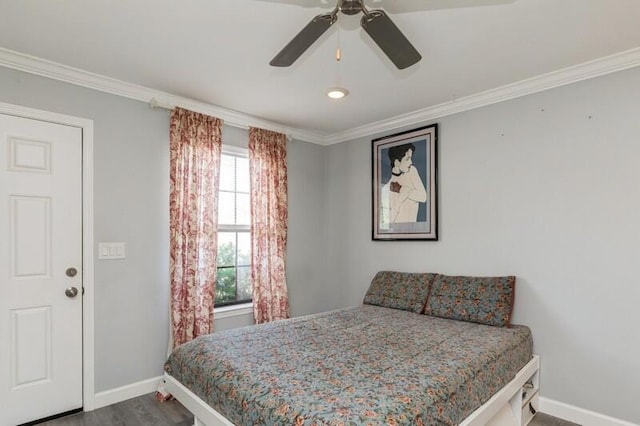 bedroom featuring ceiling fan, crown molding, baseboards, and wood finished floors