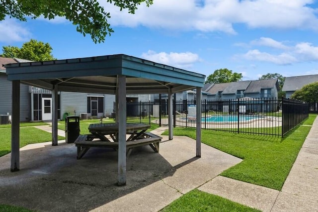 view of patio / terrace with central air condition unit, fence, a gazebo, and a community pool