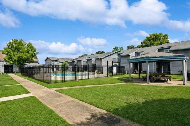 view of home's community featuring a swimming pool, a lawn, fence, and a residential view