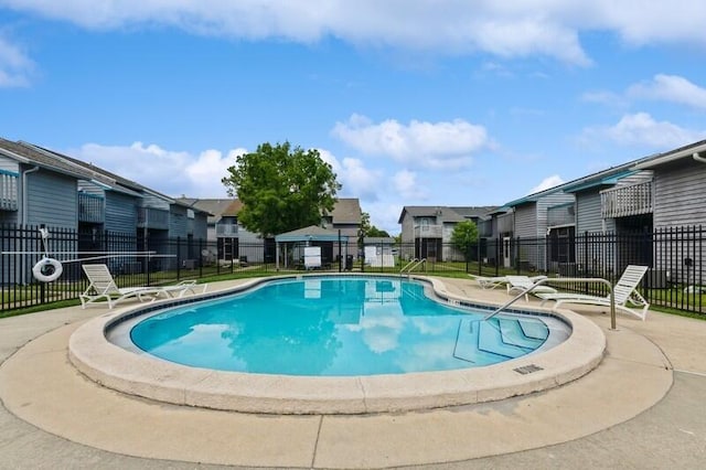 community pool with fence and a residential view