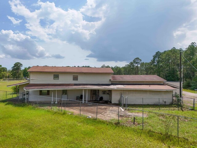 rear view of property featuring a yard