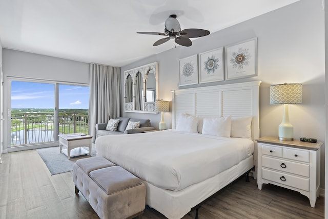 bedroom with a water view, ceiling fan, dark hardwood / wood-style flooring, and access to outside