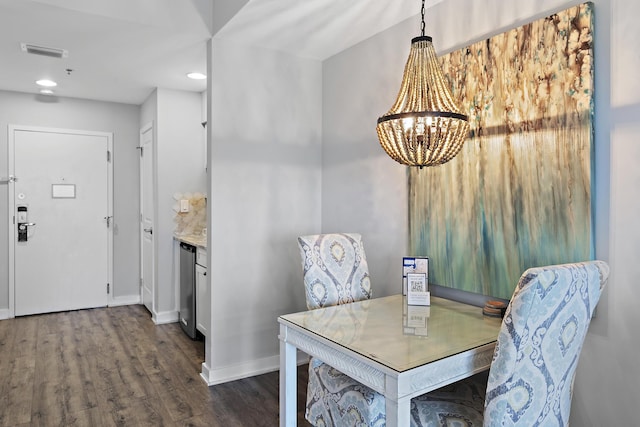 dining area featuring dark hardwood / wood-style floors and a chandelier