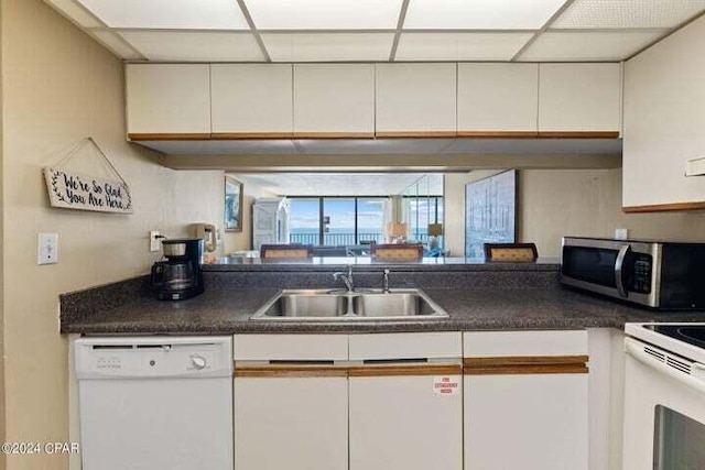 kitchen featuring white appliances, white cabinets, and sink