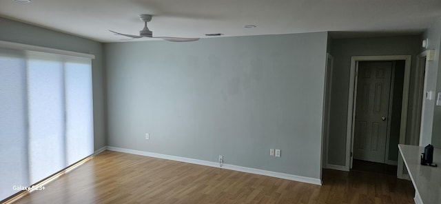 empty room featuring hardwood / wood-style flooring, ceiling fan, and plenty of natural light