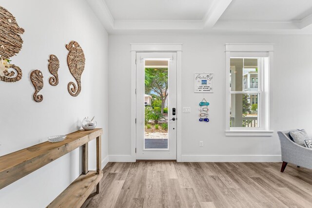 entrance foyer with light hardwood / wood-style floors and crown molding