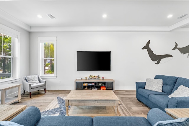 living room with a healthy amount of sunlight, hardwood / wood-style floors, and crown molding