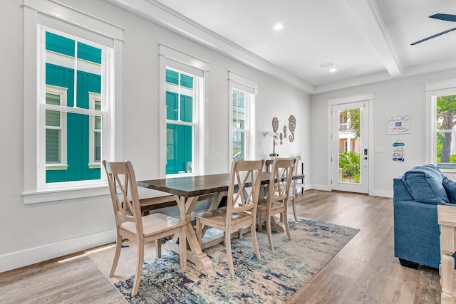 dining room with wood-type flooring, ceiling fan, beamed ceiling, and plenty of natural light